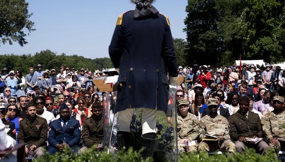Un imitador de George Washington habla con los nuevos ciudadanos estadounidenses durante su ceremonia de naturalización en Mount Vernon, Virginia, el 4 de julio de 2022. (Foto de Stefani Reynolds / AFP)