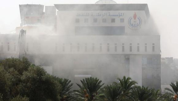 El humo asciende desde la sede de la petrolera estatal libia National Oil Corporation (NOC) luego de que tres personas enmascaradas lo atacaran en Trípoli. (Foto: Reuters)
