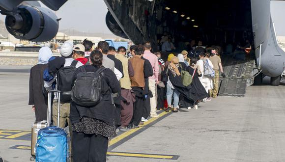 Imagen muestra a los evacuados en el escenario antes de abordar un C-17 Globemaster III durante una evacuación en el Aeropuerto Internacional Hamid Karzai, Kabul, Afganistán, el 18 de agosto de 2021. (Foto de Nicholas GUEVARA / US MARINE CORPS / AFP).