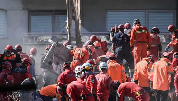 Trabajadores de rescate levantan bloques de cemento durante la operación de búsqueda en curso en el sitio de un edificio derrumbado mientras buscan sobrevivientes y víctimas en la ciudad de Izmir. (OZAN KOSE / AFP)