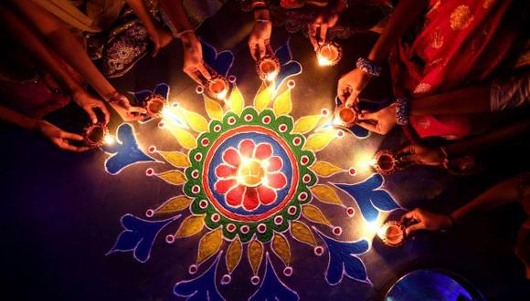 Un grupo de mujeres enciende velas sobre una flor Rangoli como decoración para el Diwali, o Festival de las Luces, en Bhopal, India. (Foto: EFE)