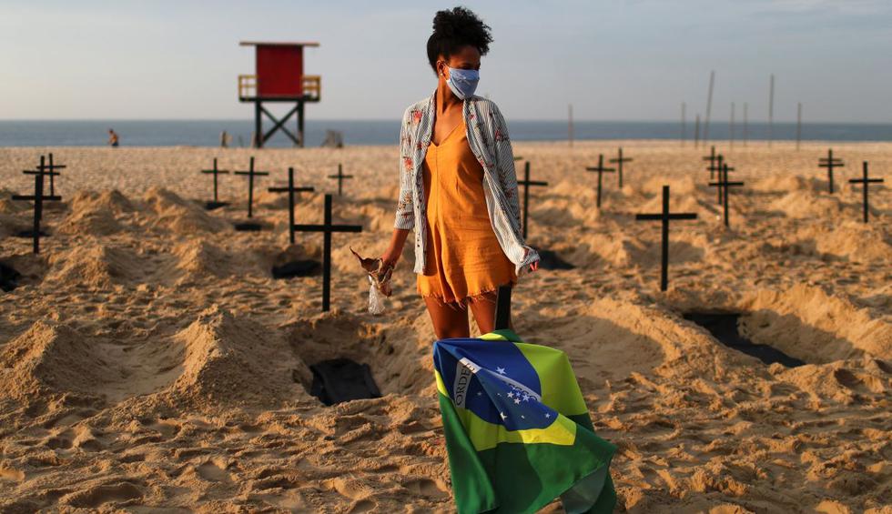 Brasileños críticos de la respuesta ambigua de su gobierno a la pandemia del coronavirus cavaron 100 tumbas y clavaron cruces negras en la arena de la playa de Copacabana en Río de Janeiro. (REUTERS/Pilar Olivares).