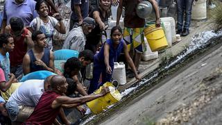 Venezolanos desesperados recogen agua del contaminado río Guaire tras el apagón