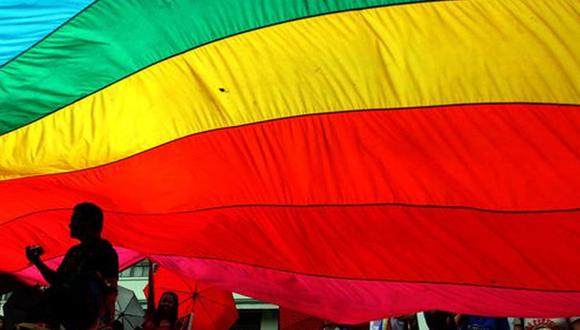Imagen referencial muestra a un activista gay recortado en la bandera del arco iris, los colores de la comunidad lésbica, gay, transgénero y bisexual (LGTB) durante un mitin. (Foto: JASON GUTIERREZ / AFP)