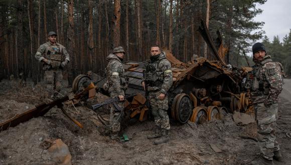 Soldados ucranianos y combatientes voluntarios inspeccionan un tanque ruso destruido en un lugar no revelado, el este de Ucrania el 10 de noviembre de 2022, en medio de la invasión rusa de Ucrania. (Foto de BULENT KILIC / AFP)