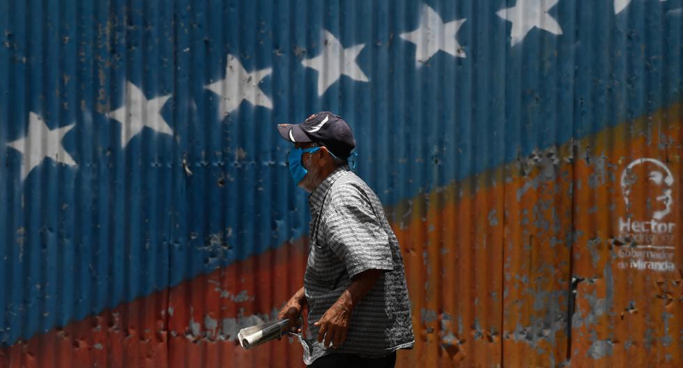 Imagen de un hombre caminando con una máscara facial en Petare. Expertos en Venezuela han indicado que el país carece de un sistema de salud “capaz de dar respuesta”. (AFP).