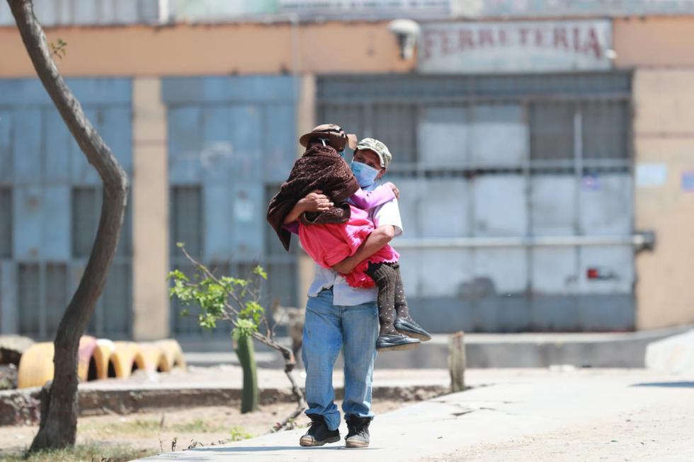 Un joven carga a su madre hasta el banco en donde recibirá el bono de S/380 para familias de extrema pobreza. (Lino Chipana/GEC)