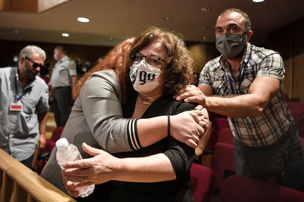 Magda Fyssa, la madre del cantante asesinado Pavlos Fyssas, es abrazada por su hija Irini tras el veredicto contra la agrupación neonazi Amanecer Dorado. (LOUISA GOULIAMAKI / AFP).