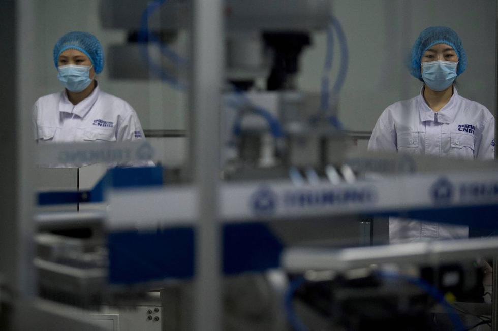 El presidente de la farmacéutica estatal china Sinopharm, Liu Jingzhen, anunció este viernes que la compañía prevé producir este año 1.000 millones de dosis de su vacuna inactivada contra el coronavirus, una buena parte de ellas destinadas a la exportación. Imagen de trabajadores en el taller de envasado en Beijing. (Texto: EFE / Foto: AFP).