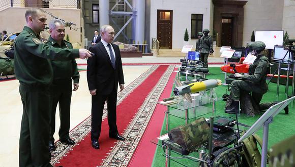 El presidente ruso Vladimir Putin y el ministro de Defensa ruso Sergei Shoigu (2º izquierda) visitan una exposición antes de la reunión anual de la junta del Ministerio de Defensa, en Moscú. (Foto: AFP)