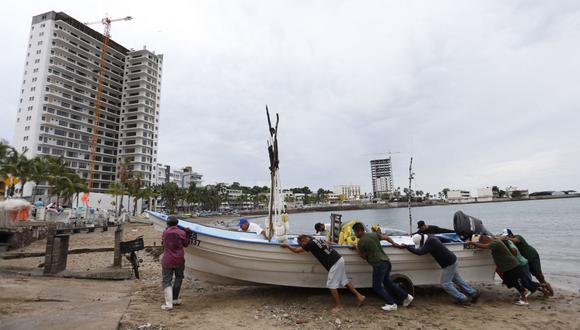 Pescadores sacan un bote del agua antes de la llegada del huracán Orlene, en Mazatlán, estado de Sinaloa, México, el 2 de octubre de 2022. (Foto de AFP)