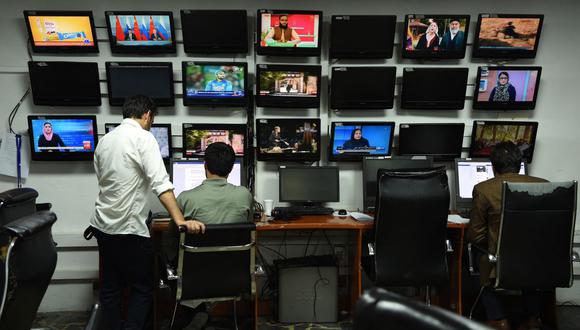 En esta foto de archivo tomada el 11 de setiembre de 2018, los reporteros afganos de Tolo News trabajan en la sala de redacción de la estación de televisión en Kabul. (WAKIL KOHSAR / AFP).