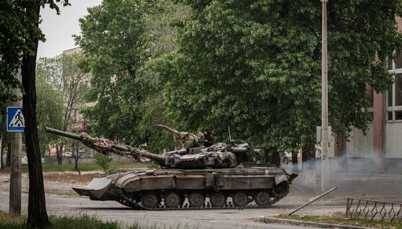 Un tanque de batalla principal ucraniano conduce por una calle durante un bombardeo de mortero cercano en Severodonetsk, este de Ucrania, el 18 de mayo de 2022, en el día 84 de la invasión rusa de Ucrania. (Foto de Yasuyoshi CHIBA / AFP)