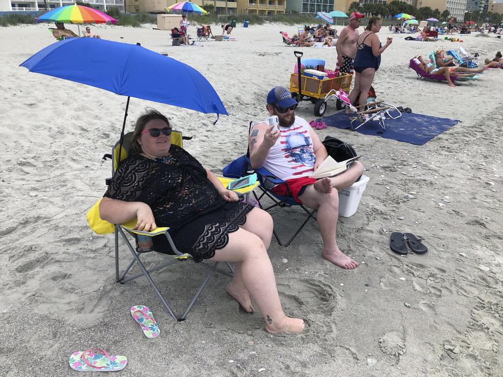 Tabatha Johnson, a la izquierda, y su esposo, Mark, disfrutan de su primer día de vacaciones en Myrtle Beach, Carolina del Sur. (Foto: AP/Jeffrey Collins)