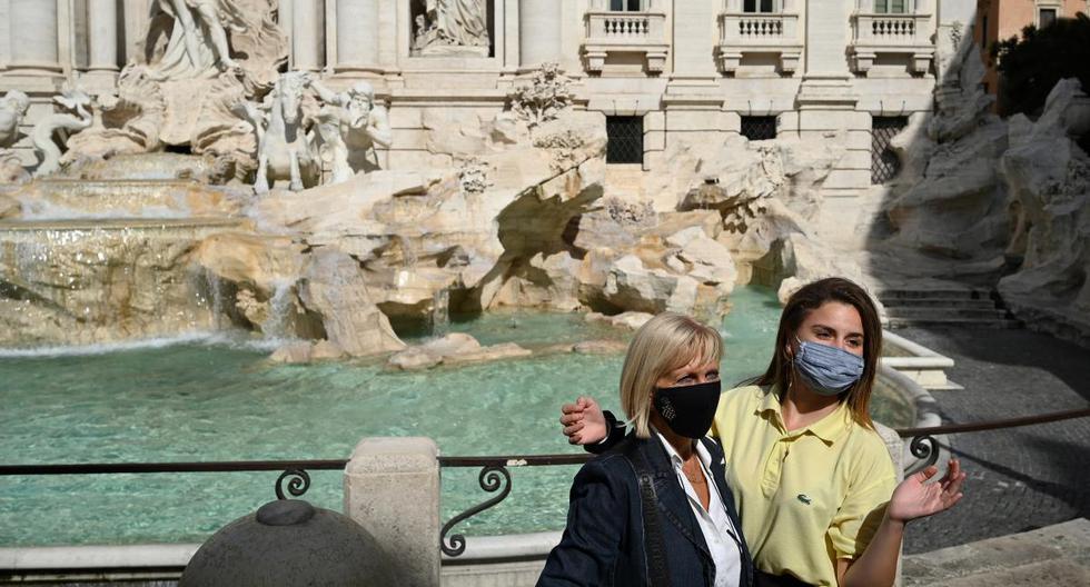Tourists wearing a face pose by the Trevi Fountain in downtown Rome on September 25, 2020 during the COVID-19 pandemic, caused by the novel coronavirus. - Italy, which was hit hard by the first wave of the coronavirus, is today an exception in Europe with a limited number of new cases, a result obtained at the price of strict anti-COVID measures, hailed on September 25, 2020 by the World Health Organization (WHO). (Photo by Vincenzo PINTO / AFP)