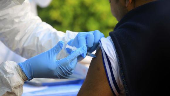 Un trabajador sanitario de la Organización Mundial de la Salud le aplica una vacuna contra el ébola a un trabajador humanitario en Mangina. (Foto: AP)