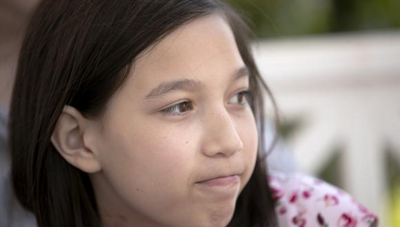 Juliet, de 12 años, se sienta con sus padres en el porche de su casa familiar en Covington, el jueves 30 de abril de 2020. (AP/Gerald Herbert)
