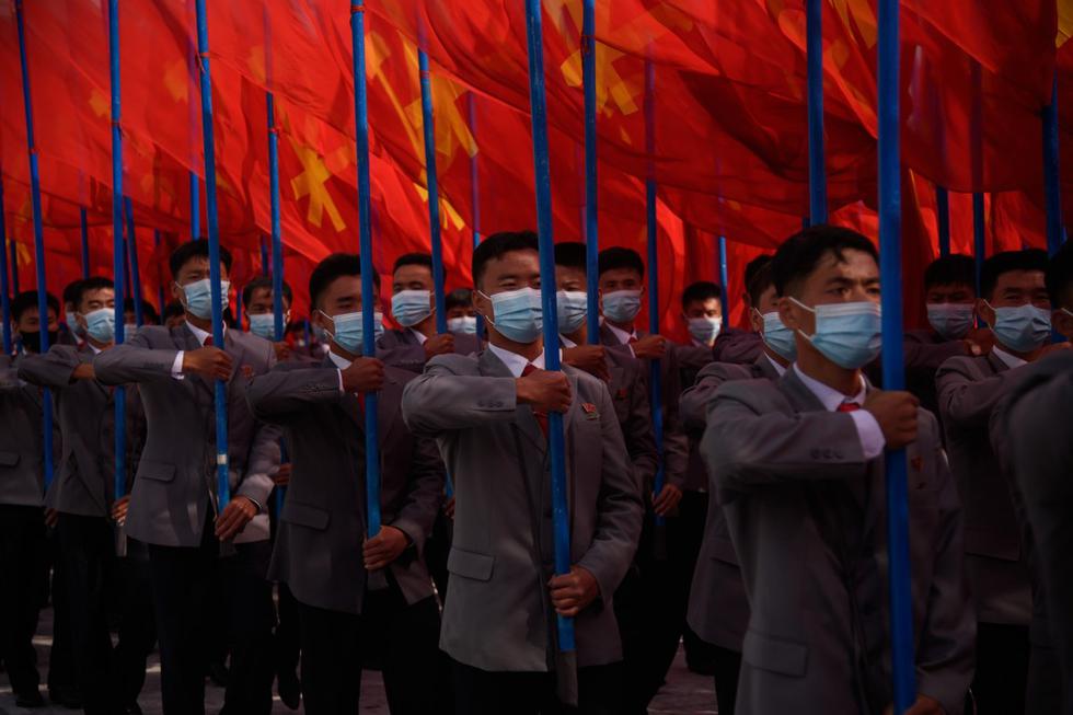 En una foto tomada el 12 de octubre de 2020, los participantes con máscaras faciales asisten a un mitin en la plaza Kim II Sung en Pyongyang, Corea del Norte. (AFP / KIM Won Jin).