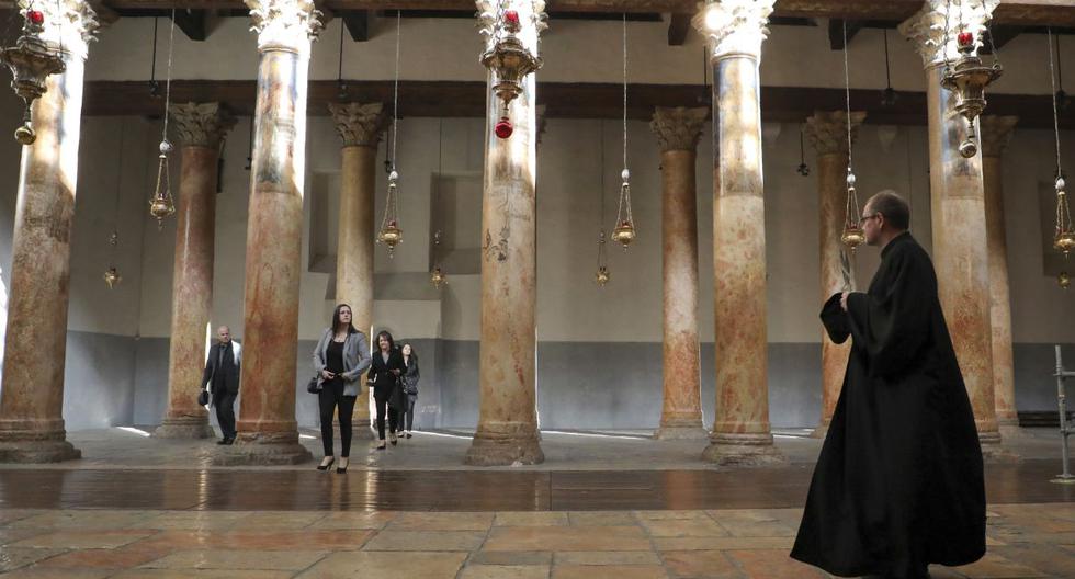 Según periodistas, la basílica estaba abierta el jueves por la mañana. Imagen de visitantes caminando en la Basílica de la Iglesia de la Natividad, en la ciudad de Belén. (AFP).