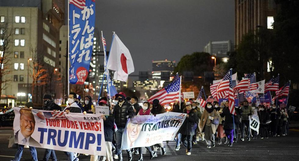 Los seguidores de Donald Trump caminan en una calle durante una manifestación en Tokio, Japón, el 6 de enero de 2021.  (EFE/EPA/FRANCK ROBICHON).