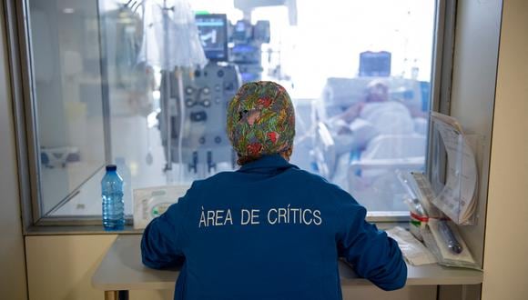 Un trabajador de la salud observa a un paciente con Covid-19 a través de la ventana, en la Unidad de Cuidados Intensivos (UCI) del Hospital Universitario de Bellvitge en Barcelona el 19 de enero de 2022. (Foto: Josep LAGO / AFP)