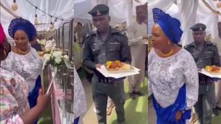 Redes sociales indignadas por video de policía nigeriano cargando plato de comida de una mujer en fiesta