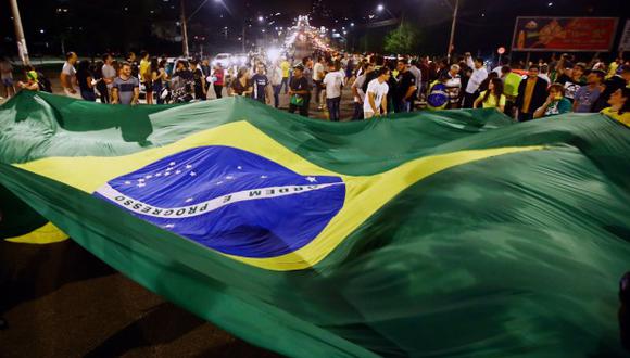Los activistas que apoyan la operación Lava-Jato celebran tras la llegada del ex presidente brasileño Luiz Inácio Lula da Silva a la sede de la Policía Federal para cumplir su condena de 12 años de prisión. (Foto: AFP)