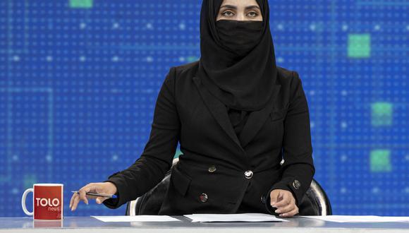 Una presentadora de Tolo News, Thamina Usmani, se cubre el rostro en una transmisión en vivo en la estación de televisión Tolo en Kabul el 22 de mayo de 2022. (Foto de Wakil KOHSAR / AFP)
