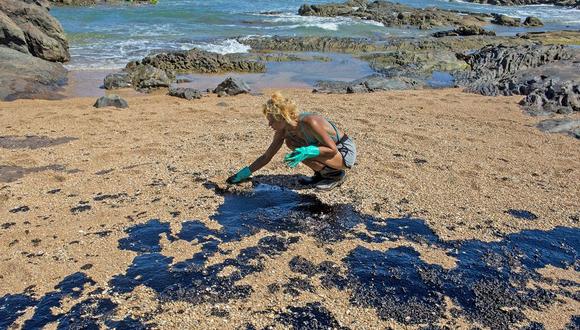 Un voluntario limpia el petróleo de la arena en una playa de un centro vacacional en Porto de Busca Vida en Lauro de Freitas, estado de Bahia, Brasil. (Foto: AFP)