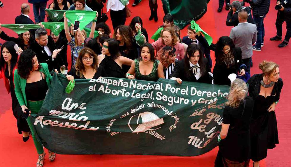 Activistas a favor del aborto marchan detrás de una pancarta y saludan con la bufanda del movimiento a favor de la elección argentina cuando llegan para la proyección de la película "Let It Be Law (Que Sea Ley)". (Foto: AFP)
