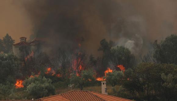El humo se eleva desde los incendios cerca de las casas en el área de Afidnes, cerca de Atenas, Grecia, el 6 de agosto de 2021. (EFE/EPA/ALEXANDER BELTES).