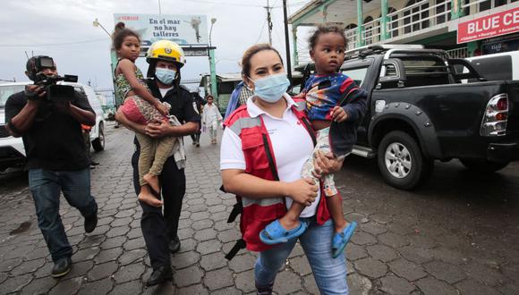 Miembros de la Defensa Civil ayudan a evacuar a niños en el puerto de Blufields antes de la llegada de la tormenta tropical Bonnie al pueblo de Bluefields, Nicaragua, el 1 de julio de 2022. (Foto de OSWALDO RIVAS / AFP)