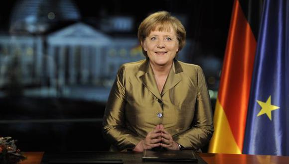Merkel dio su mensaje con las banderas de Alemania y la Unión Europea, y el edificio del Parlamento de fondo. (Reuters)
