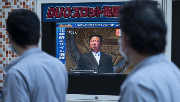 La gente pasa frente a una pantalla de televisión pública en Tokio el 4 de octubre de 2022, que muestra imágenes de archivo del líder de Corea del Norte, Kim Jong Un, durante una transmisión sobre el lanzamiento de un misil norcoreano temprano en la mañana que provocó una alerta de evacuación en el noreste de Japón. (Foto de Richard A. Brooks / AFP)