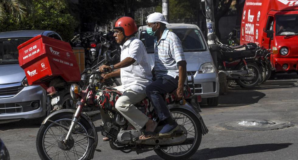 Un residente usa una máscara facial en una motocicleta en Karachi  cuando Pakistán detectó sus dos primeros casos de nuevos coronavirus. (AFP).