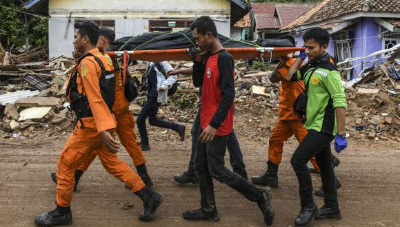 Miembros de un equipo indonesio de búsqueda y rescate llevan el cuerpo de una víctima recuperada de una casa colapsada en una bolsa de cadáveres en Rajabasa, en la provincia de Lampung. (Foto: AFP)