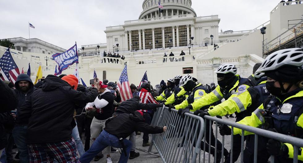 En esta fotografía de archivo del miércoles 6 de enero de 2021, partidarios de Donald Trump intentan atravesar una barrera policial en el Capitolio de Washington (Estados Unidos). (AP/Julio Cortez)