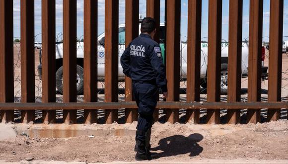 En la foto, una unidad de la patrulla fronteriza y un guardia de la policía federal de México cerca de la valla fronteriza entre Estados Unidos y México. (Foto: AFP)