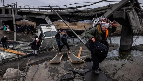 Los evacuados cruzan un puente destruido mientras huyen de la ciudad de Irpin, al noroeste de Kiev, el 7 de marzo de 2022. (Foto: Dimitar DILKOFF / AFP)