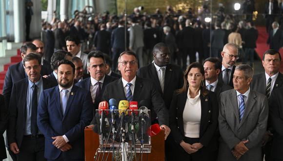 El presidente brasileño Jair Bolsonaro (C) hace una declaración por primera vez desde la segunda vuelta de las elecciones presidenciales del domingo, en el Palacio Alvorada en Brasilia. (Foto por EVARISTO SA / AFP)