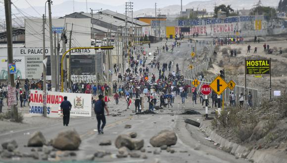 Manifestantes bloquean la carretera Panamericana durante una protesta en el Cono Norte de Arequipa, Perú, el 12 de diciembre de 2022. - Dos manifestantes más murieron en Perú el lunes cuando las violentas manifestaciones por el derrocamiento del expresidente no dieron señales de amainar - - a pesar de los esfuerzos de su sucesor por sofocar los disturbios. (Foto de Diego Ramos / AFP)