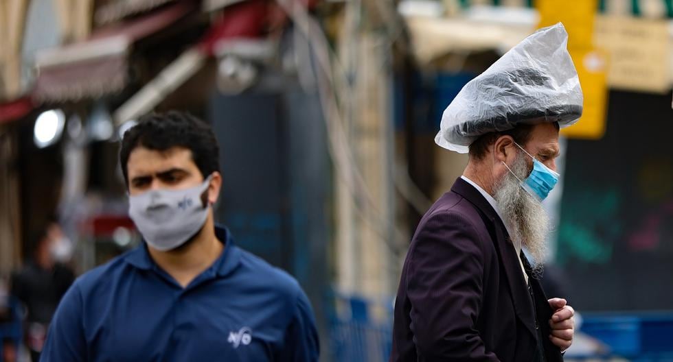Las personas usan máscaras protectoras mientras caminan en el centro de Jerusalén, el 28 de enero de 2021. (Emmanuel DUNAND / AFP).