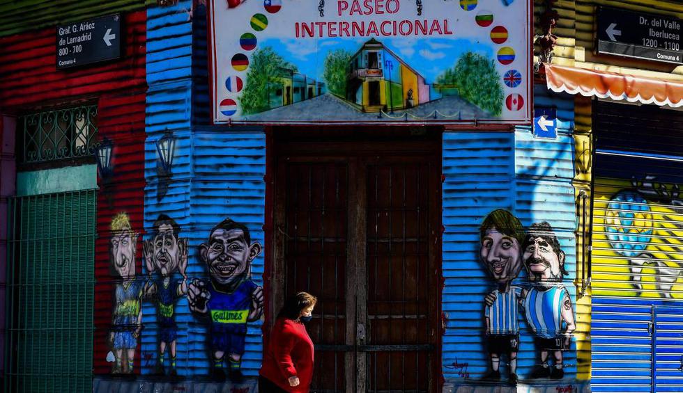 Una mujer pasa frente a un restaurante cerrado en el barrio de La Boca en Buenos Aires (Argentina). (AFP / Ronaldo SCHEMIDT).