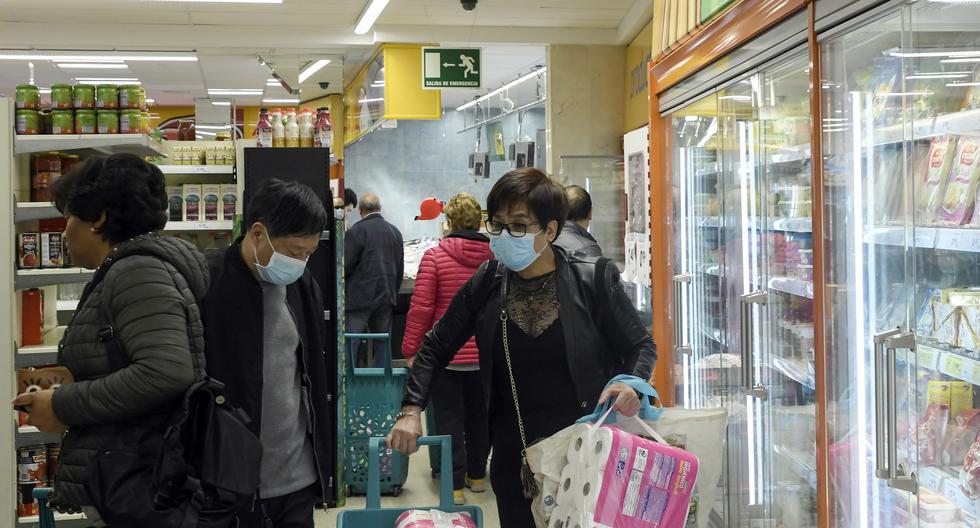 Las personas, algunas de ellas con máscaras protectoras a la luz del nuevo brote de coronavirus, hacen las compras en un supermercado en el barrio de Usera en Madrid. (AFP).
