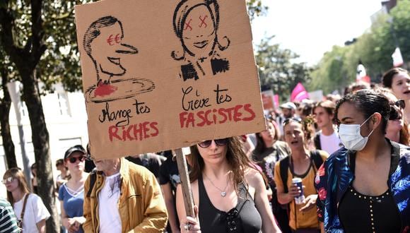 Una manifestante sostiene un cartel que representa al presidente francés y candidato, Emmanuel Macron, y la candidata  Marine Le Pen. (Foto: Sebastien SALOM-GOMIS / AFP)