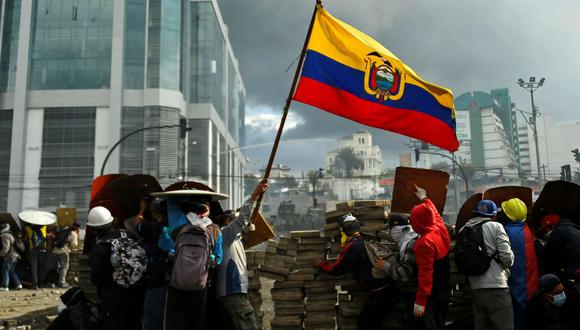 Los manifestantes ondean una bandera de Ecuador durante los enfrentamientos con la policía antidisturbios en los alrededores del parque El Arbolito en Quito, el 24 de junio de 2022. (RODRIGO BUENDIA / AFP).