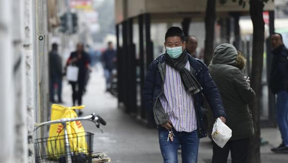 Un hombre con una máscara respiratoria camina en una calle del distrito chino de Milán. La decisión de cerrar las tiendas de dicho lugar fue tomada por la comunidad china de la ciudad de Milán. (AFP)