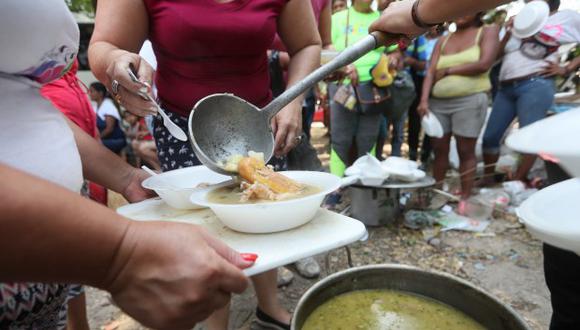 Personas reparten comida este domingo en las inmediaciones del puente Francisco de Paula Santander en la frontera entre Venezuela y Cúcuta. (Foto: EFE)