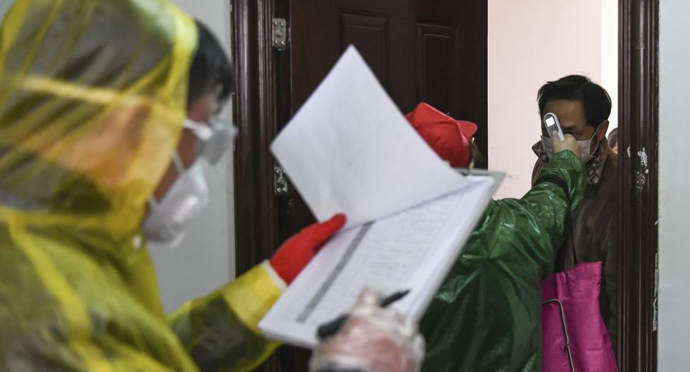 En esta foto publicada por la Agencia de Noticias Xinhua, los trabajadores van de puerta en puerta para verificar la temperatura de los ciudadanos durante una campaña de evaluación de salud en Wuhan. (AP).