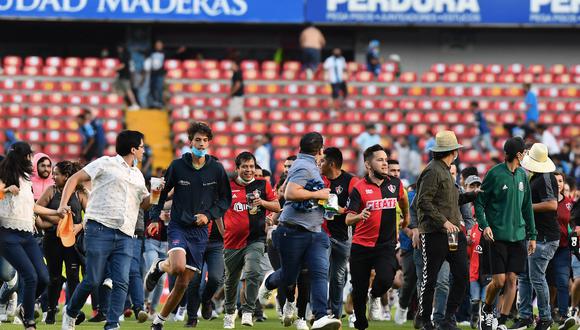 Seguidores del equipo de fútbol Atlas ingresan al campo durante el partido del torneo de fútbol mexicano Clausura 2022 contra Querétaro en el estadio Corregidora en Querétaro, México, el 5 de marzo de 2022. (Foto: AFP)